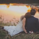 Bride and Groom Sitting on the Edge of a Lake